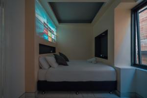 悉尼Cozy M Hotel的卧室配有一张大床,墙上配有电视