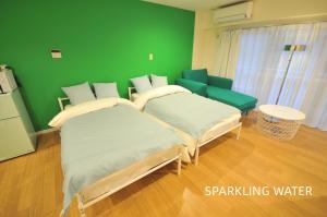 大阪Maison Milano Nakatsu Apartment的绿墙客房的两张床