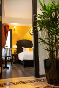 河内Hanoi Center Silk Boutique Hotel & Travel的一间酒店客房,配有床和盆栽植物