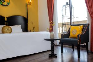 河内Hanoi Center Silk Boutique Hotel & Travel的一间卧室配有一张床、一把椅子和一张桌子