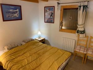 Le BiotChalet proche Morzine et lac Léman WIFI offert的卧室配有床、椅子和窗户。