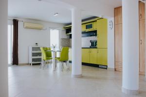 特罗吉尔Villa Vinko的厨房配有黄色橱柜和桌椅