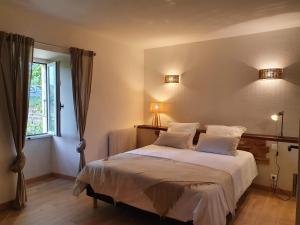 Flaujac-PoujolsLa Quintarde的一间卧室配有一张带白色床单的床和一扇窗户。