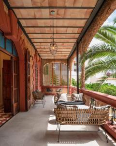 马略卡岛帕尔马Hotel Can Quetglas的户外庭院设有柳条家具和木制天花板