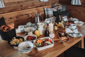 布格贝格Alpzitt-Chalets的木桌,上面放有盘子和碗的食物
