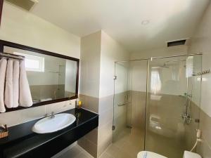 Tây NinhHotel Mỹ Mỹ的一间带水槽和玻璃淋浴的浴室