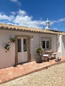 法鲁Vila Lobo Algarve的房屋设有带桌子的庭院和建筑
