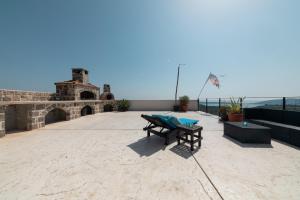 KlinciLuxury Holidays & Events - Villa Diva - Montenegro的一座带桌子和长凳的庭院,位于一座建筑的顶部