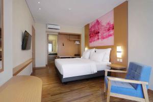 巴淡岛中心favehotel Nagoya - Batam的酒店客房,配有白色的床和椅子
