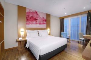 巴淡岛中心favehotel Nagoya - Batam的卧室配有一张白色大床和一张书桌