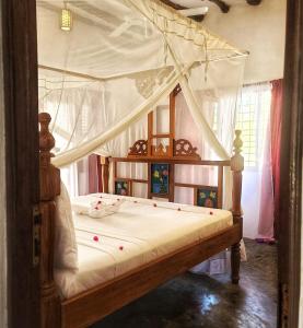 江比阿MARS A.K. VILLAS的卧室配有带白色床单的天蓬床