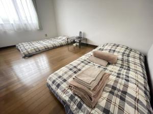 小樽京樽3号 1棟貸切 一軒家 3-Bedrooms Duplex Private Villa KYOTARU3的一间卧室设有两张床,铺有木地板