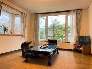 小樽京樽3号 1棟貸切 一軒家 3-Bedrooms Duplex Private Villa KYOTARU3的客厅配有桌椅和窗户。