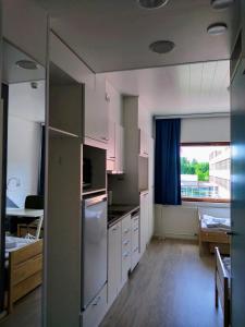 于韦斯屈莱Harju Apartments的一间厨房,配有白色的橱柜和大窗户