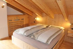 利维尼奥Bike&Ski Centro Apartments的一间带一张床的卧室,位于带木制天花板的房间内