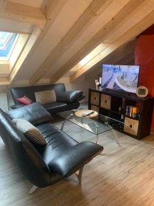 CorcapoloTolles Loft in den Tessiner Bergen的客厅配有黑色真皮沙发和电视