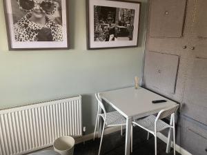 特灵Wellbrook Rooms的墙上挂着照片的桌子和椅子