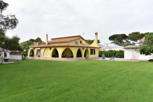 普拉villa Letizia的一座大型黄色房子,拥有大型的绿色庭院
