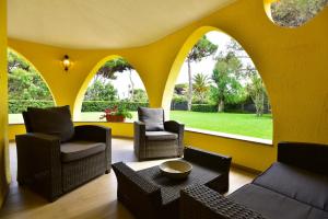 普拉villa Letizia的客厅设有黄色的墙壁、椅子和桌子