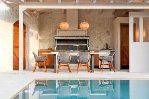 康托卡利My Mediterranean Corfu Luxury Villa with Private Swimming Pool的游泳池旁的厨房配有桌椅