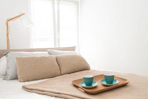 奥尔什丁Apartment City Centre Netflix- GreenPark - River的床上有两杯蓝色的杯子的托盘