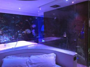 阿西西Luxury Spa Suite Superior Assisi的一间带浴缸的浴室和室内水族馆的卧室