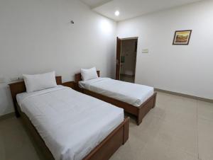 海得拉巴White Fern Stays Serviced Apartments - Gachibowli的白色墙壁客房的两张床