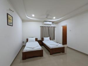 海得拉巴White Fern Stays Serviced Apartments - Gachibowli的客房设有两张床和天花板上的电视。
