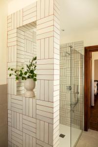 Leporano MarinaPozzo Traverso Casale的浴室设有玻璃淋浴间和盆栽植物