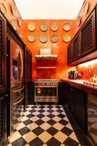 马拉喀什Palais El Roucar的厨房拥有橙色的墙壁和 ⁇ 格地板