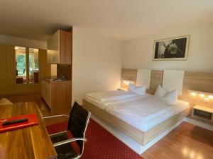 慕尼黑慕尼黑阿帕特中心酒店的一间卧室配有一张床、一张桌子和一张桌子