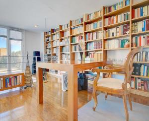 马略卡岛帕尔马VILLA BONANOVA STYLE的一个带木桌和椅子的图书馆
