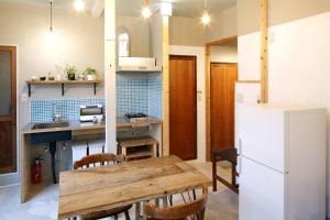 东京東京光明旅舍的厨房配有木桌和冰箱。