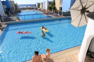 帕福斯埃莱尼渡假酒店的一群人在游泳池玩耍