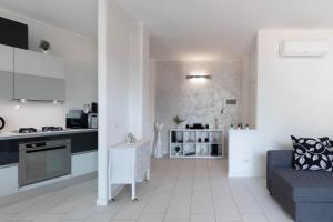 莱科TERRAZZA SUL LAGO - Open Space e Netflix的白色的厨房和带沙发的客厅