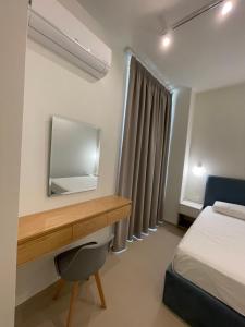 LlogaraHeaven Residence - Green Coast Resort, Palasë的一间卧室配有书桌、一张床和镜子