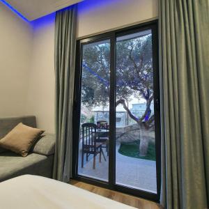 萨兰达Villa Mehmeti的一间卧室设有窗户,享有庭院的景色