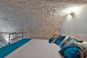 奥斯图尼AROMA luxury的卧室配有砖墙内的床铺