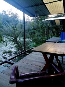 兰金Room in Cabin - Rafting Hut by The River的木甲板配有桌子和椅子