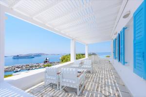 图罗斯Adikri Villas & Suites的阳台配有白色椅子,享有水景。