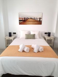 比利亚里科斯Áticos Cala Verde Playa的一间卧室配有一张床,上面有两条毛巾