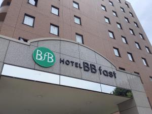 米泽市HOTEL BB fast Yonezawa的一座酒店大楼,前面有标志