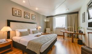 圣保罗圣保罗佩斯塔纳酒店的酒店客房设有一张大床和一张书桌。