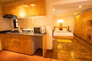 帕坦Patan Wittys hotel的一个带水槽的厨房和一张位于客房内的床