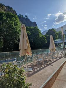 安道尔城西拉库萨酒店的游泳池旁的一排椅子和遮阳伞