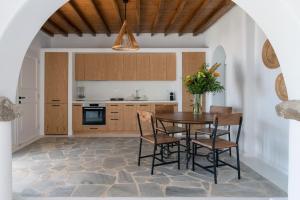 圣爱奥尼斯米科诺斯Nefes Residence 2 bedroom villa的一间厨房,里面配有桌椅