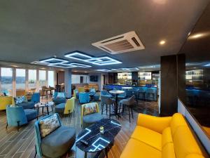 马六甲CHRISTEE SUITES HOTEL的餐厅设有黄色的沙发和桌椅