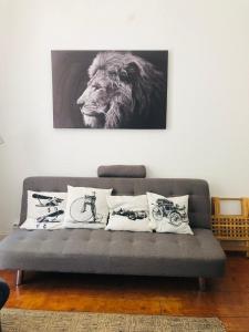 里斯本Casa do Mocho II的一张带枕头的沙发以及一幅狮子的照片
