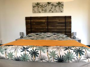 莱萨维龙Pamplemousse & Passion - 3 étoiles的一间卧室配有一张带橙色床头板的大床