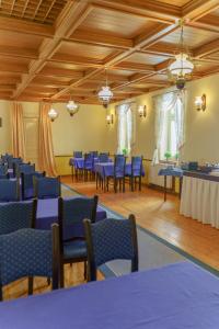 卡罗维发利哈鲁恩酒店的大房间设有蓝色的桌椅